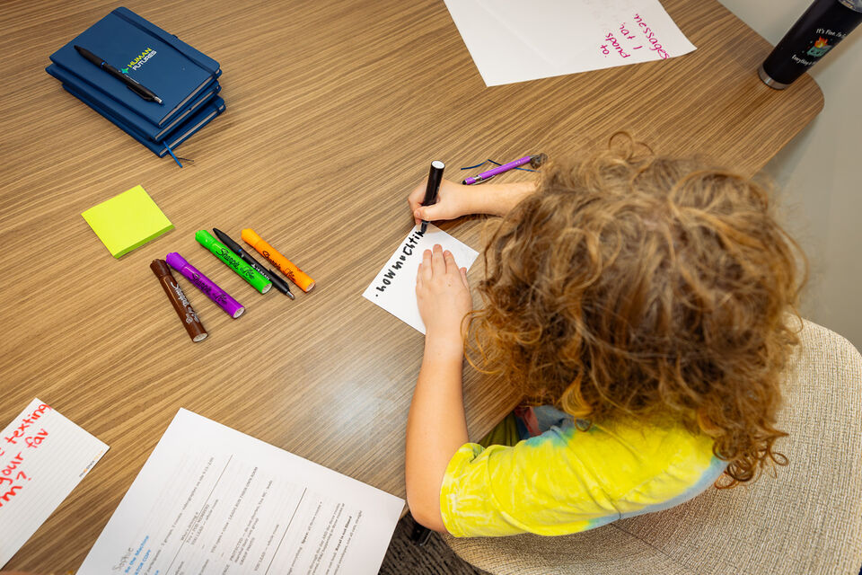 Overhead view of the cohort writing exercises by hand in Human Futures notebooks
