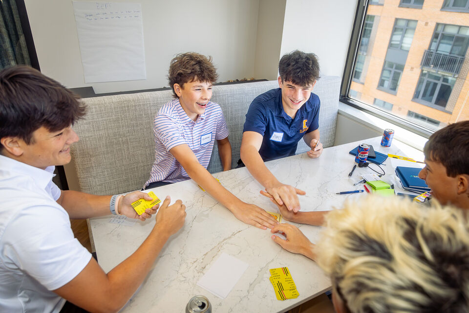 Students laughing together during a card game exercise