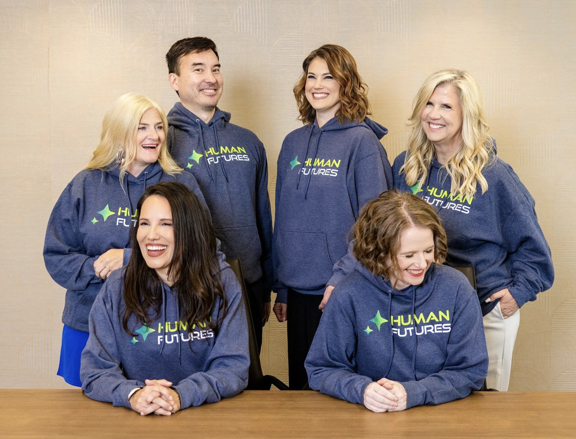 PhoenixTeam partners sharing a lighthearted moment in Human Futures hoodies